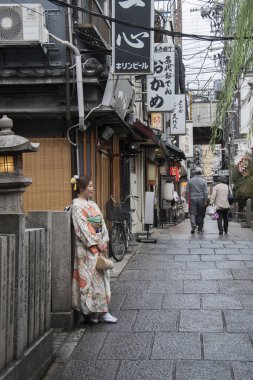 İnsanlar Osaka 'da Hozenji Yokocho' da yürüyor.