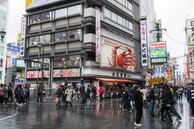 İnsanlar Japonya 'nın Osaka kentindeki Dotonbori caddesini ziyaret ediyorlar. 