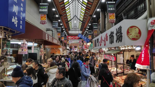 Los compradores visitan el mercado Nipponbashi Kuromon Ichiba en Osaka Japón —  Fotos de Stock