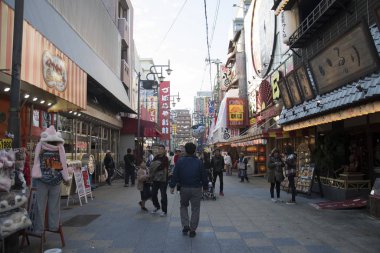 İnsanlar Japon Osaka 'nın Minami bölgesindeki Shinsekai mahallesini ziyaret ediyor.
