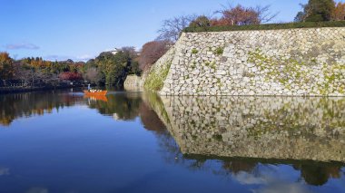 Gemiyle gezen turistler Himej 'de sonbaharın güzel gidişini izlerler.