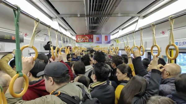 Los pasajeros viajan en un tren de metro lleno de gente en Kyoto . — Foto de Stock