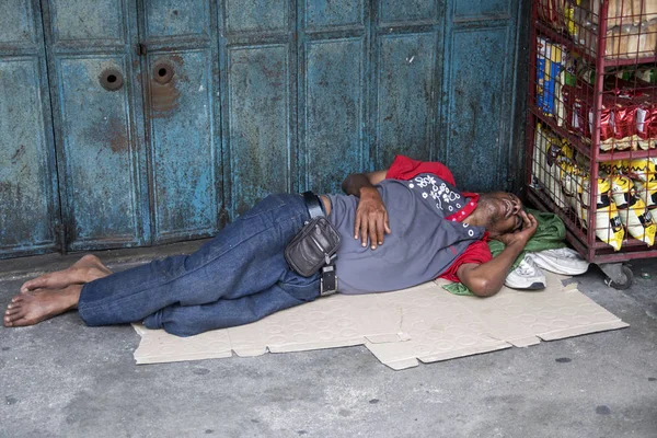 Indian beggar sleeps on the street in Johor Bahru. — Stock Photo, Image
