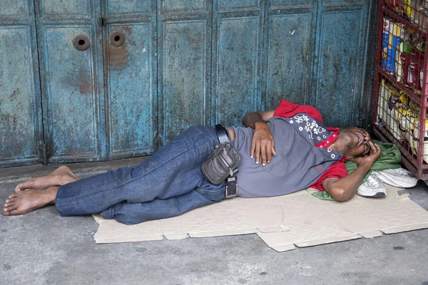 Indian beggar sleeps on the street in Johor Bahru. — Stock Photo, Image