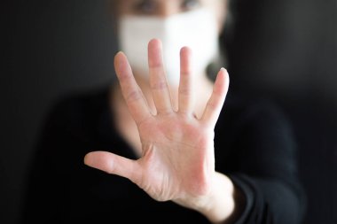 Maske takan yaşlı bir kadın temiz ellerini gösteriyor ve Corona virüsünü durdurmak için el hareketi yapıyor. Koronavirüs ve salgın virüs belirtileri..