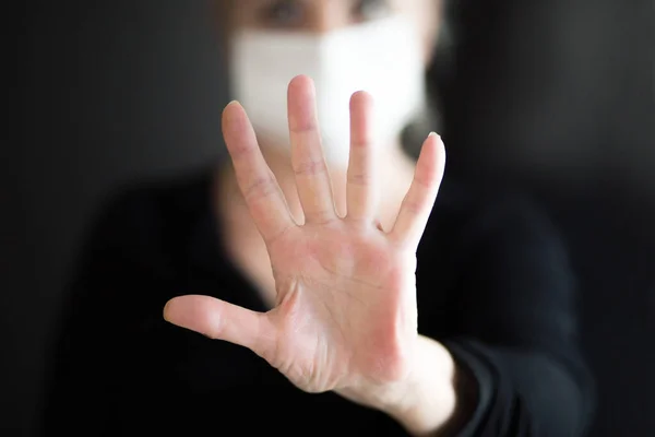 Maske takan yaşlı bir kadın temiz ellerini gösteriyor ve Corona virüsünü durdurmak için el hareketi yapıyor. Koronavirüs ve salgın virüs belirtileri..
