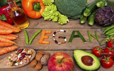 vegan kelime ahşap arka plan ve sebze - gıda
