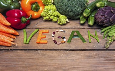vegan kelime ahşap arka plan ve sebze - gıda