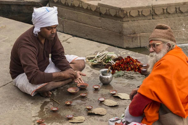 Varanasi, Indien - 03. Januar 2020: zwei nicht identifizierte hinduistische Sadhu-Heilige sitzen auf dem Ghatt in der Nähe des Ganges-Flusses in Varanasi, Indien. Tourismus hat viele angebliche Fake Sadhus nach Varanasi gelockt — Stockfoto