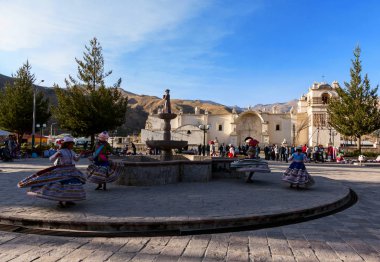 Chivay, köyün meydanındaki fıskiyenin etrafında geleneksel elbiselerle dans eden joung kızları.
