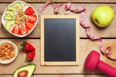 Fındıklı yulaf, avokado, taze çilek ve ahşap masada meyvelerden oluşan sağlıklı bir kahvaltı, ortada fotokopi alanı.