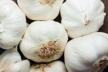 Beyaz sarımsak dokusu. Pazar masasında taze sarımsak. Yakın plan fotoğraf. Vitamin sağlıklı yiyecek baharatı görüntüsü. Baharatlı yemek malzemesi resmi. Beyaz sarımsak kafalar. Beyaz sarımsak kafa üst görünüm