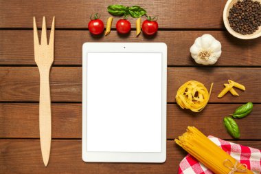 Beyaz tablet, ahşap zemin üzerinde fotokopi alanı ile İtalyan makarnası pişirmek için malzemeler, üst görünüm