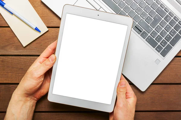 Çalışma masasında dijital tablet boş ekranı gösteren el.