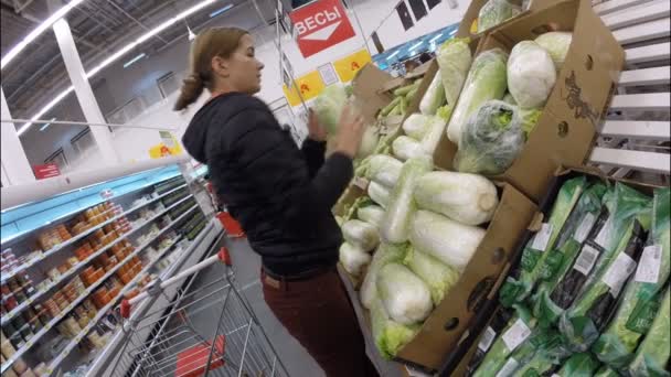 UFA, RUSIA - 7 de julio de 2016: La chica está de compras en el supermercado Auchan. En Rusia hay más de cien tiendas Auchan — Vídeo de stock