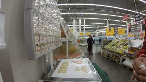 UFA, RUSIA - 7 de julio de 2016: El hombre compra comida en el supermercado Auchan En Rusia hay más de cien tiendas Auchan — Vídeo de stock