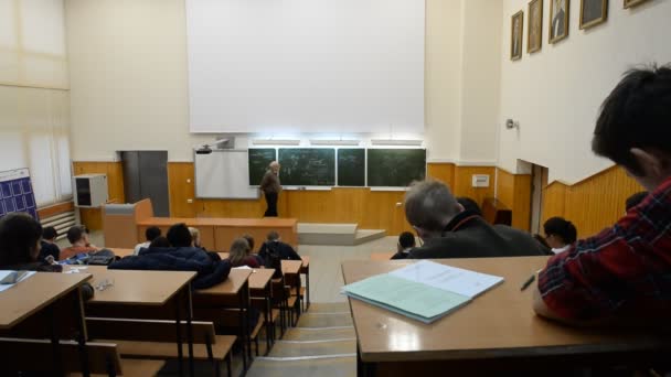 Universidade Estadual. Estudantes em um grande auditório universitário ouvindo uma palestra — Vídeo de Stock