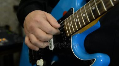 Gitarist elektrik gitar çalıyor. Yakın çekim 