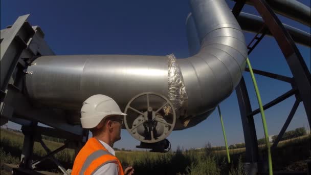 Der Ingenieur öffnet und schließt das Ventil an der industriellen Pipeline für Warmwasser und Heizung, Gas, Öl, Ressourcen — Stockvideo