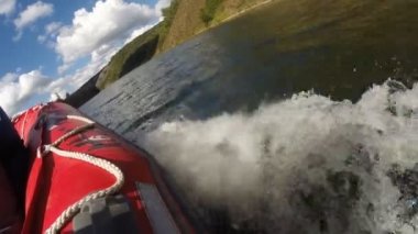 Motorlu tekne göl boyunca hızla ilerliyor.