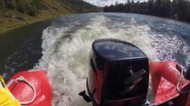 Motorlu tekne göl boyunca hızla ilerliyor.