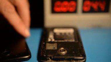 Laboratuvarda lehimleyerek akıllı telefonun ana kartını tamir eden teknisyen elinin yakın çekimi. bilgisayar donanımı, cep telefonu, elektronik, onarım, güncelleme ve teknoloji kavramı.