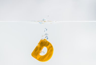 Sarı ahşap alfabe D suya beyaz arkaplan ve seçici odak ile düşer