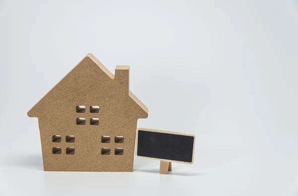 Houten huisspeelgoed en klein zwart bord met witte achtergrond en selectieve focus — Stockfoto