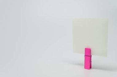 Beyaz arka plan ve seçici odak pembe ahşap küçük tarafından klempe not kağıdı