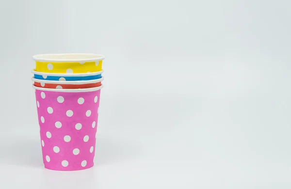 Куча разноцветной бумажной чашки на белом фоне и выборочная фокусировка — стоковое фото