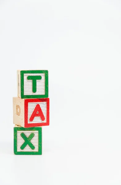 TAX word wooden block arrange in vertical style on white background and selective focus — Stock Photo, Image