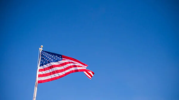 USA Drapeau américain agitant avec un fond bleu ciel clair en vue horizontale — Photo