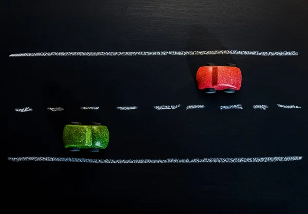 Brinquedo de carro de madeira vermelho e verde na estrada de placa de giz — Fotografia de Stock