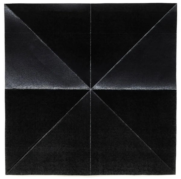 Papier noir plié en 8 parties avec diagonale sur fond blanc — Photo