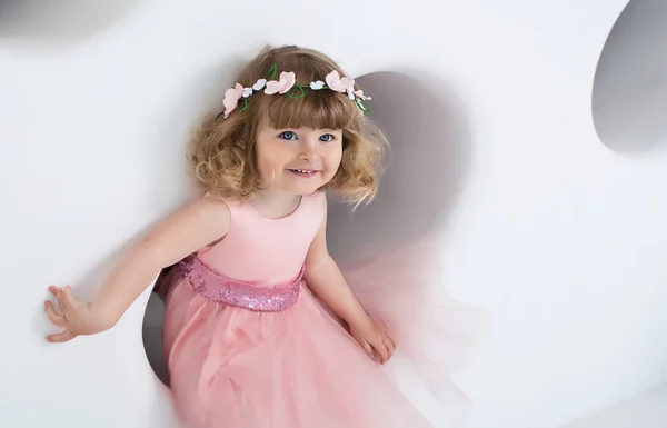 Klein Meisje Roze Jurk Glimlacht Witte Kamer — Stockfoto