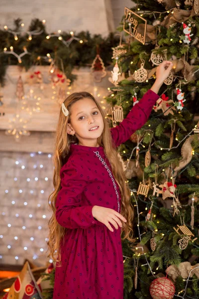 크리스마스 근처의 아름다운 아이가 크리스마스 트리를 장식합니다 머리를 소녀의 — 스톡 사진