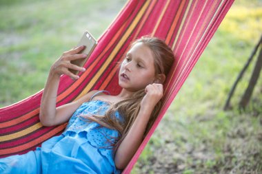 Çocuk parkındaki küçük kız. Hamaktaki küçük kız