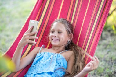 Çocuk parkındaki küçük kız. Hamaktaki küçük kız