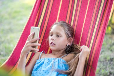 Çocuk parkındaki küçük kız. Hamaktaki küçük kız