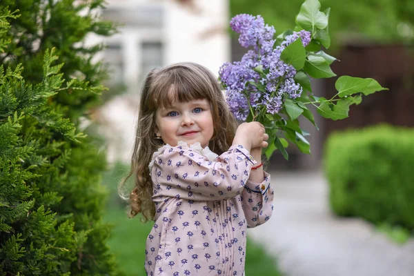 Kleines Mädchen Mit Blühenden Fliederzweigen Der Nähe Ihres Hauses — Stockfoto