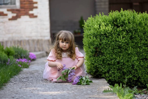 Kleines Mädchen Mit Blühenden Fliederzweigen Der Nähe Ihres Hauses — Stockfoto