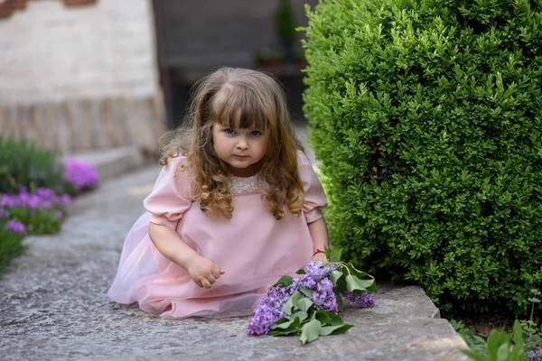 Kleines Mädchen Mit Blühenden Fliederzweigen Der Nähe Ihres Hauses — Stockfoto