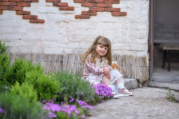 Een Klein Meisje Met Een Pop Meisje Met Een Bloem — Stockfoto