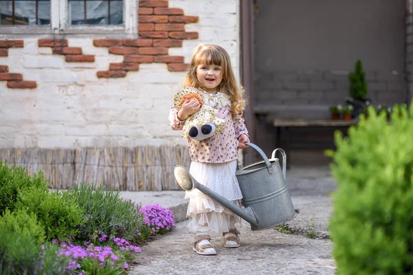 Dziewczynka Konewką Lalką Ogrodzie — Zdjęcie stockowe
