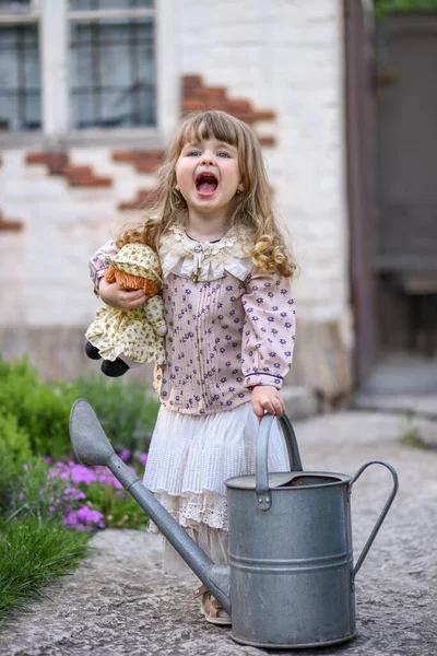 Kleines Mädchen Mit Gießkanne Und Puppe Garten — Stockfoto