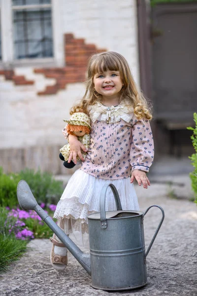 Kleines Mädchen Mit Gießkanne Und Puppe Garten — Stockfoto