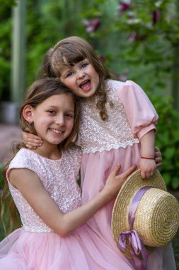 Kız kardeşler parkta eğleniyor. Mutlu kardeşler.