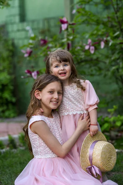 Kız kardeşler parkta eğleniyor. Mutlu kardeşler.