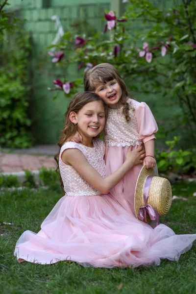 Kız kardeşler parkta eğleniyor. Mutlu kardeşler.