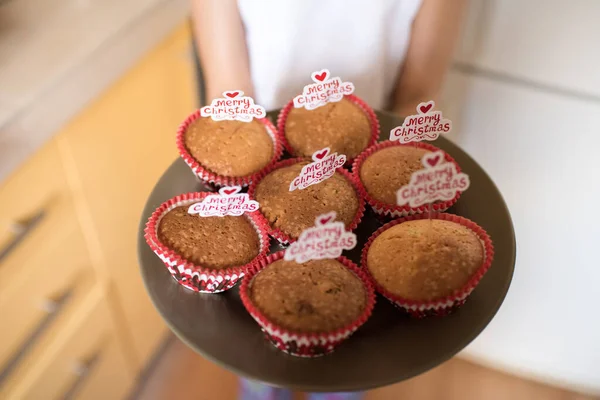 女の子ホールディングトレイとともにメリークリスマスカップケーキ — ストック写真
